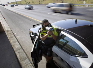 This image shows an officer using a Laser device to obtain a ''reading'' from oncoming vehicles. Our traffic attorneys near me know how to challenge such speed detection technology.